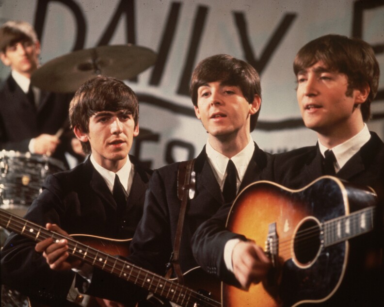 25th November 1963: A group shot of the Beatles, Ringo Starr (in the background), George Harrison (1943 - 2001), Paul McCartney and John Lennon (1940 - 1980), pictured during a performance on Granada TV's Late Scene Extra television show filmed in Manchester, England on November 25, 1963. (Photo by Fox Photos/Getty Images)