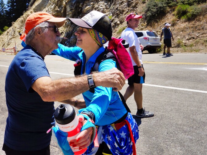                                Longtime trail runner and race director Steve Harvey greets Martine Sesma as she completes the 26th mile of the Angeles Crest 100. 