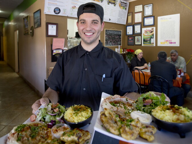 Kareem Hawari with two Chicken Greatness dishes in his restaurant in Anaheim, California on September 28th, 2016.