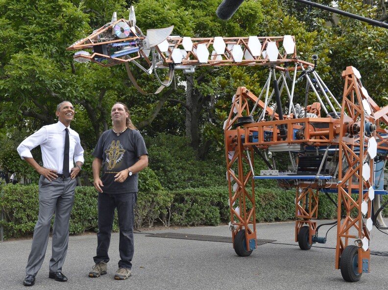 U.S. President Barack Obama (L) talks with Lindsay Lawlor of San Diego, California, the builder of a robotic giraffe at the White House Maker Faire projects on the South Lawn June 18, 2014 in Washington, DC. The Faire is a series of projects by students,  entrepreneurs and regular citizens using new technologies and tools to launch new businesses and learning new skills in science, technology, engineering and mathematics.   