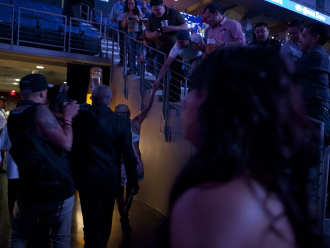 "La Barbie" shakes hands with a fan on her way to the locker room.