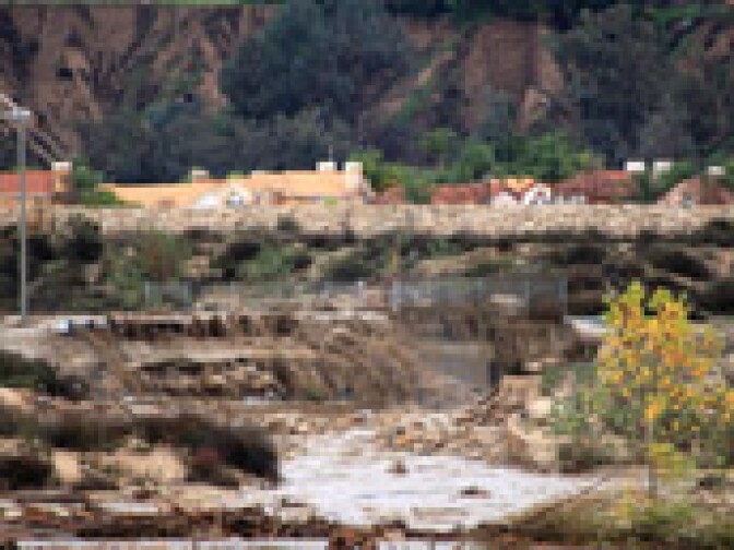 The swollen Santa Ana River crests the Baseline Avenue bridge in Highland on the morning of Wednesday, Dec. 22, 2010, causing extensive damage.