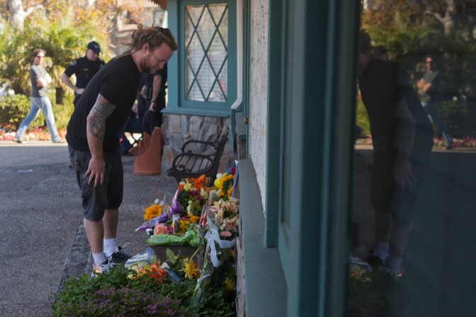 A mourner places flowers at the site of a mass killing in Seal Beach that took place the day before on October 12, 2011. A stream of people stopped by throughout the day to grieve.