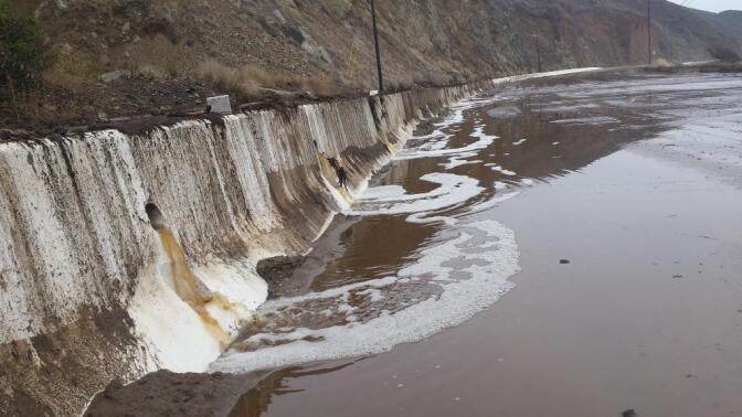 Water and mud cover Pacific Coast Highway north of Deer Creek Road after Sunday's rains forced its closure. 