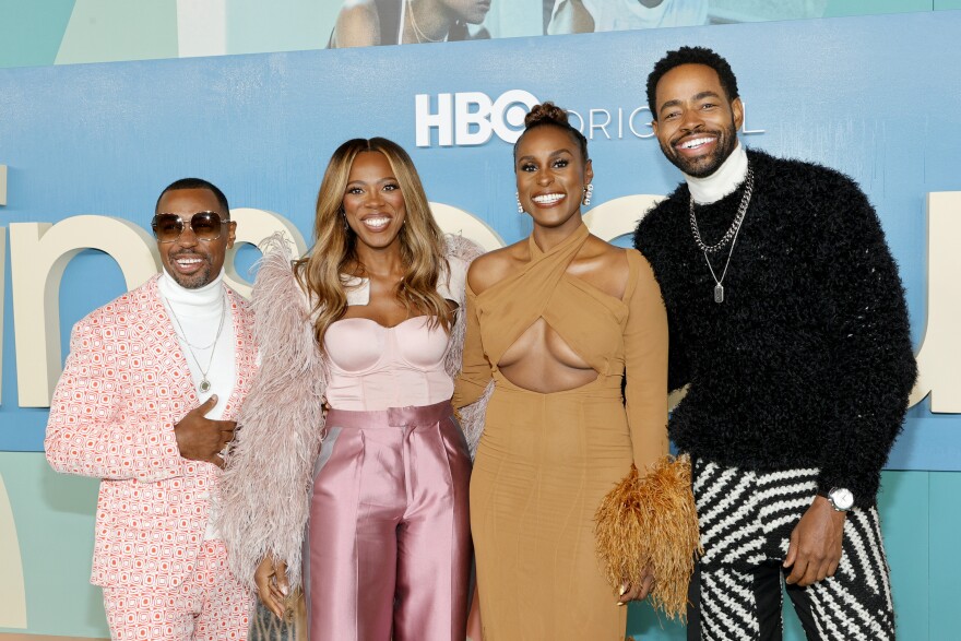 An image of four cast members of the TV series Insecure, wearing trendy outfits at the final season premiere of the HBO show.