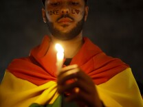Activists in Sao Paulo, Brazil carry lit candles and flags at a vigil paying tribute to the victims of the Orlando nightclub massacre.