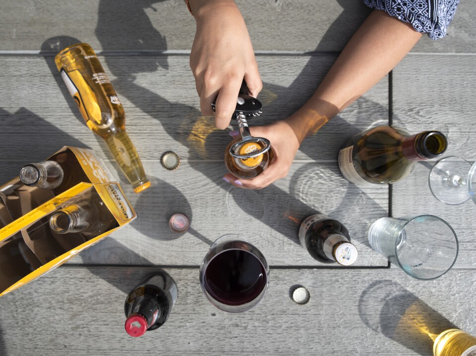 An array of beer bottles sit on a picnic table.