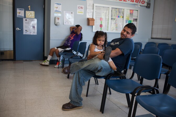 Alondra Manzanarez and her father David wait for care at the South Central Family Health Center. They do not have insurance and have been coming to the center for three years.