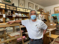 Brian Kito, the third-generation owner of Fugetsu-Do,  leans on the counter in his mochi shop.