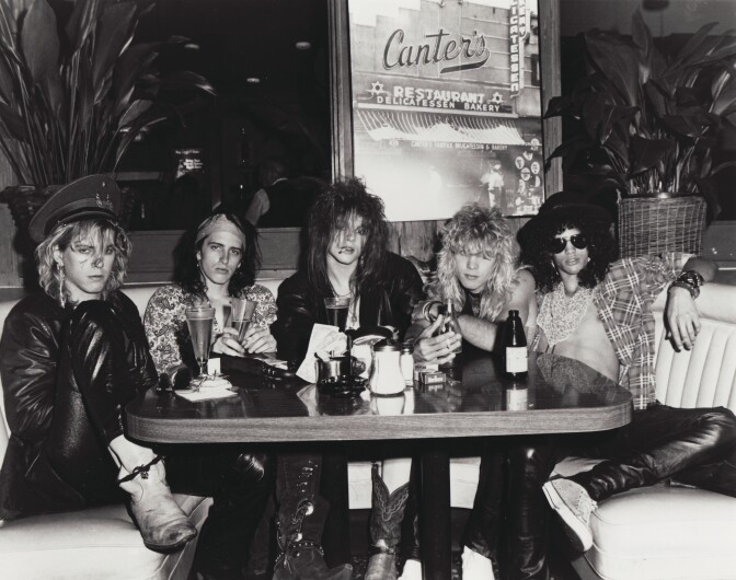 Members of Guns N' Roses sitting at a Canter's Deli booth. 