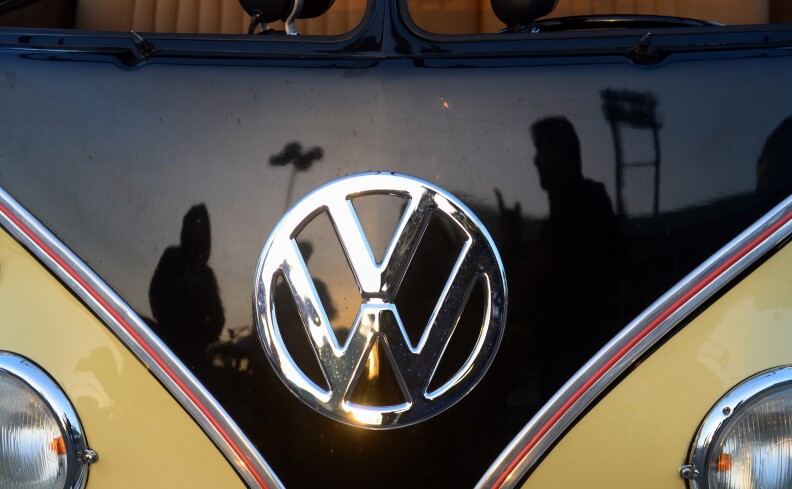 File: People reflected in a refurbished 1959 Volkswagen Kombi, discuss cars at 'Das O.C.T.O. Fest 2013', a swap and display gathering for enthusiasts and owners of 1967 and earlier models of the classic vehicle in Long Beach, California on October 12, 2013. 
