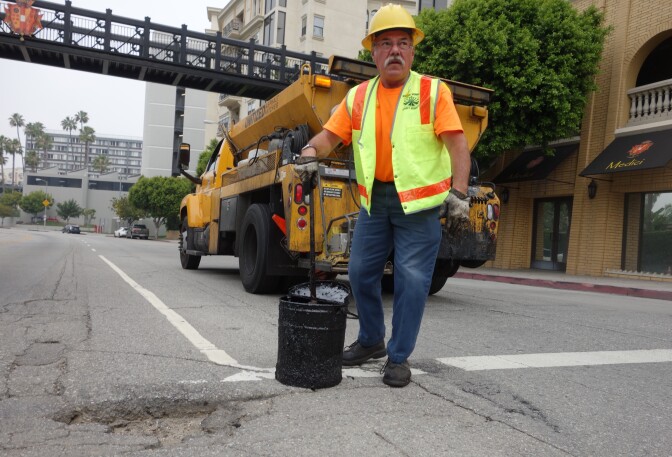 Los Angeles city worker Hugo Vasquez reviews a pothole that needs filling at 8th Street and Bixel Ave. downtown.