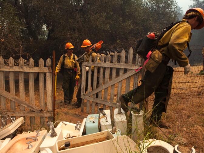 Firefighters clear vegetation near a home in Hidden Valley, Calif., on May 3, 2013.