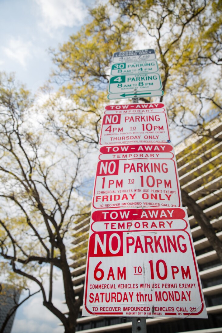 Confusing parking signs stacked on top of each other.