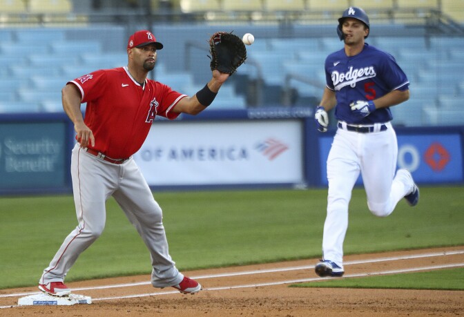 LOS ANGELES, CALIFORNIA - MARCH 30: Albert Pujols #5 of the Los Angeles Angels makes a catch to get out Corey Seager #5 of the Los Angeles Dodgers on March 30, 2021 in Los Angeles, California. (Photo by Meg Oliphant/Getty Images)