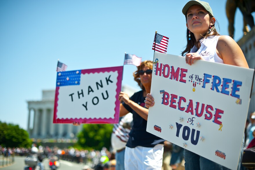 File: Two women hold up signs thanking the troops as members of the US military veterans' Rolling Thunder bikers group ride past in Washington on May 26, 2013 as the country marks Memorial Day. 