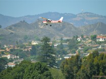 A 1977 Cessna 150M N714HH flies over Santa Paula, California on September 16, 2013. 