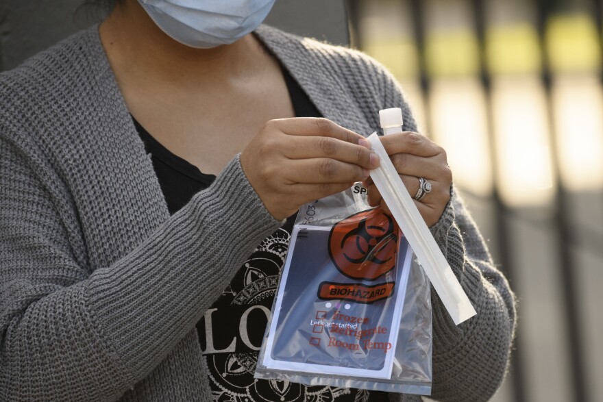 A person opens a Covid-19 oral swab test at a pop-up community testing site in the Panorama City neighborhood of Los Angeles, California, December 9, 2020. (Photo by Patrick T. Fallon / AFP) (Photo by PATRICK T. FALLON/AFP via Getty Images)
