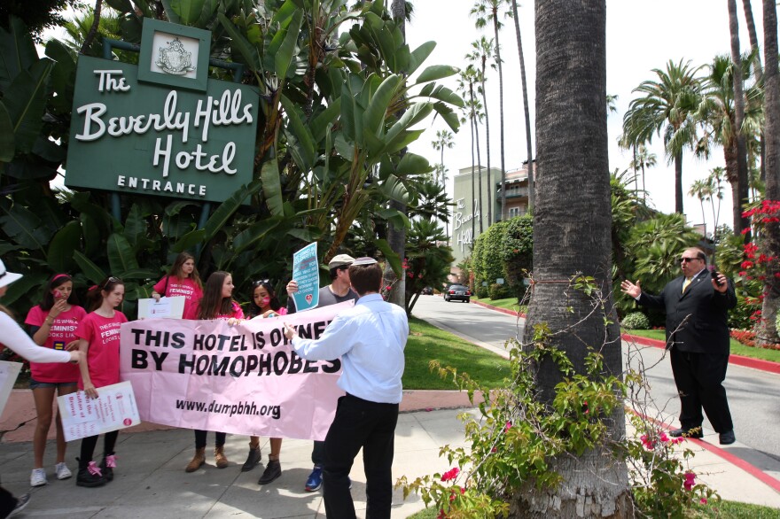BEVERLY HILLS, CA - MAY 5:  A security guard confronts demonstrators protesting draconian punishment of women and gay people announced by the Sultan of Brunei on a sideway near the entrance to the Beverly Hills Hotel, which is owned by the Sultan, on May 5, 2014 in Beverly Hills, California. The Sultan of Brunei is planning to implement a brand of Sharia Penal Code which calls for the stoning of people for various offenses including homosexual acts, adultery, sodomy and extramarital sexual relations, a move that has been criticized by The United Nations. (Photo by David McNew/Getty Images)
