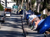 FILE - This Tuesday, Jan. 26, 2016 file photo shows tents from a homeless encampment line a street in downtown Los Angeles. Los Angeles city and county officials have approved sweeping plans to deal with homelessness at a cost of billions over a decade. The City Council's strategic plan calls for providing more housing and funding programs designed to keep people off the streets in the first place. The city has around 25,000 homeless, more than half the total in LA County. (AP Photo/Richard Vogel,File)