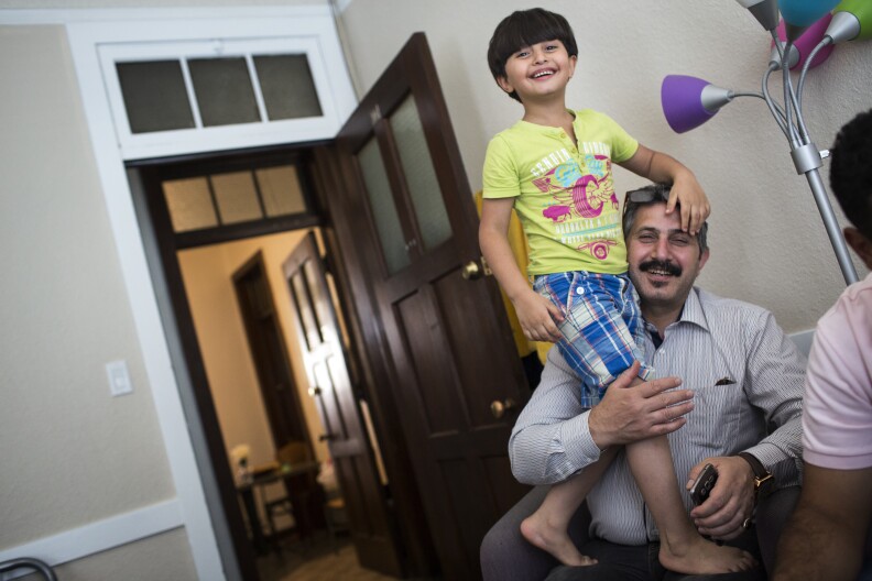 Seven-year-old Abed Rahman Kanjou, left, plays with his father, Abdul Maman Kanjou, in their temporary housing in Pomona on Monday afternoon, Aug. 29, 2016. The refugee family of six arrived in the United States two weeks ago from Syria.