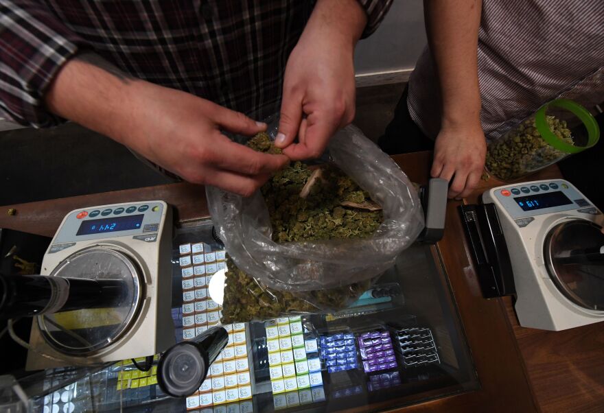 File: A salesman prepares an order of marijuana products at the Perennial Holistic Wellness Center, which is a medicinal marijuana dispensary in Los Angeles, California on March 24, 2017. 