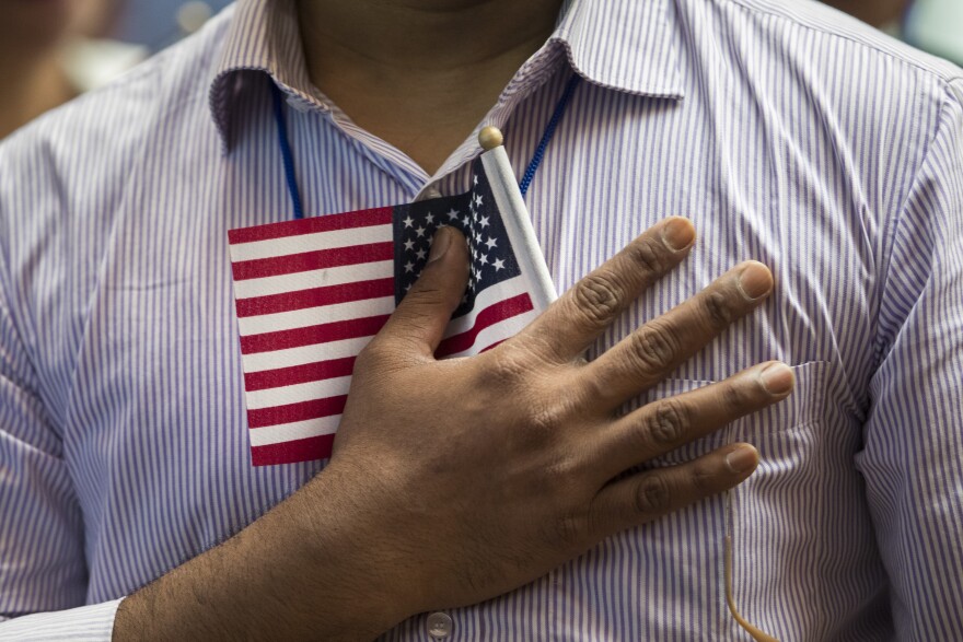NEW YORK, NY - JULY 3: A new U.S. citizen holds a flag to his chest during the Pledge of Allegiance during a naturalization ceremony at the New York Public Library, July 3, 2018 in New York City. 200 immigrants from 50 countries became citizens during the ceremony, one day before America's Independence Day. (Photo by Drew Angerer/Getty Images)