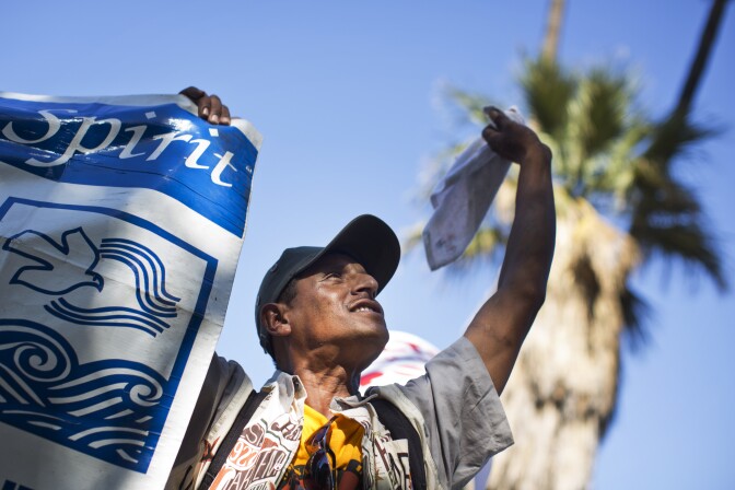 Rodrigo Ortiz, an employee at the Pomona Day Labor Center, waves at the Metropolitan Detention Center during a march on Wednesday, Aug. 27 supporting immigrant worker protections in any administrative relief plan that President Obama announces in the coming weeks.