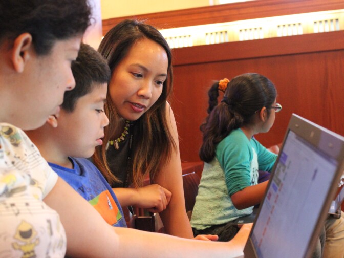 Children's librarian Joanna Fabicon (center) provides feedback to a student