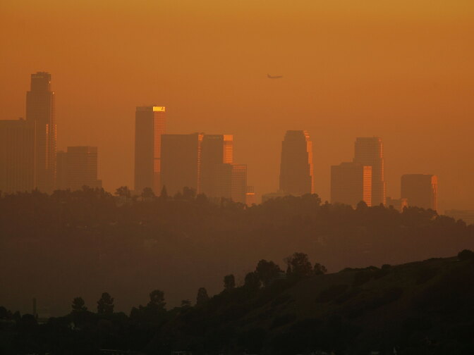The downtown skyline is enveloped in smog shortly before sunset in Los Angeles, California.