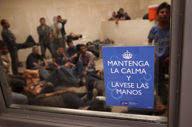 MCALLEN, TX - SEPTEMBER 08: Undocumented immigrants wait in a holding cell at a U.S. Border Patrol processing center for people detained near the U.S.-Mexico border on September 8, 2014 in McAllen, Texas. The sign, written by the U.S. Centers for Disease Control (CDC), reads "Keep Calm and Wash Your Hands." Thousands of immigrants, many of them families and unaccompanied minors, continue to cross illegally into the United States, although the numbers are down from a springtime high. Texas' Rio Grande Valley area is the busiest sector for illegal border crossings into the United States. (Photo by John Moore/Getty Images)