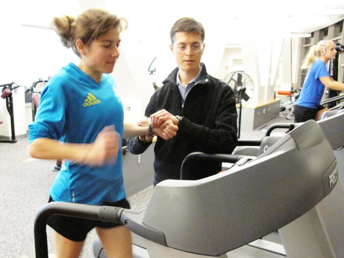 Ben Rapoport takes Erin Wyner's pulse as she runs on a treadmill to determine how many carbohydrates she should eat to run a successful marathon.