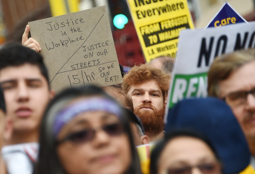 Fast food workers, healthcare workers and their supporters shout slogans at a rally and march to demand an increase of the minimum wage to 15USD per hour, in Los Angeles on December 4, 2014.