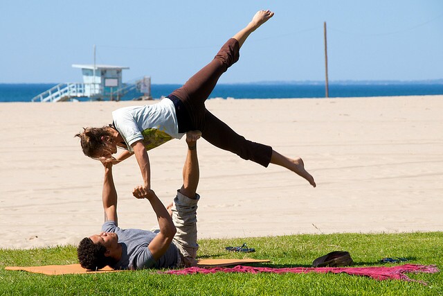 A couple does a yoga workout on the beach in Los Angeles.