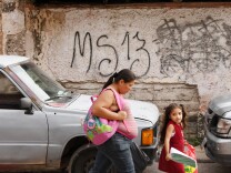 ocal residents pass by a grafitti made by the Mara Salvatrucha (MS-19) gang in the MS-13-controlled El Bosque neighborhood in Tegucigalpa, on May 9, 2017.
The territorial fight beweeen both rival gangs keeps the neighbors terrified. / AFP PHOTO / ORLANDO SIERRA / TO GO WITH AFP STORY BY NOE LEIVA        (Photo credit should read ORLANDO SIERRA/AFP/Getty Images)