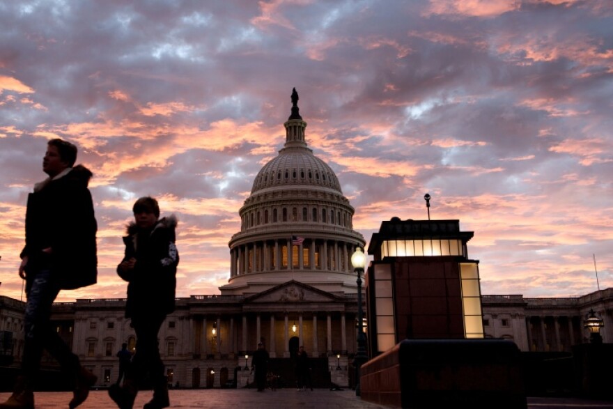 The U.S. Capitol building seen from a distance at sunset.
