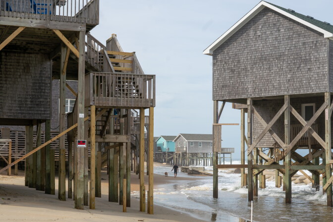 Houses built on the shoreline of a beach.