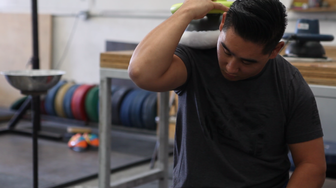Weightlifting coach Sam Chang uses a car buffer on his shoulders at Waxman's Gym in Lawndale in October 2017. 