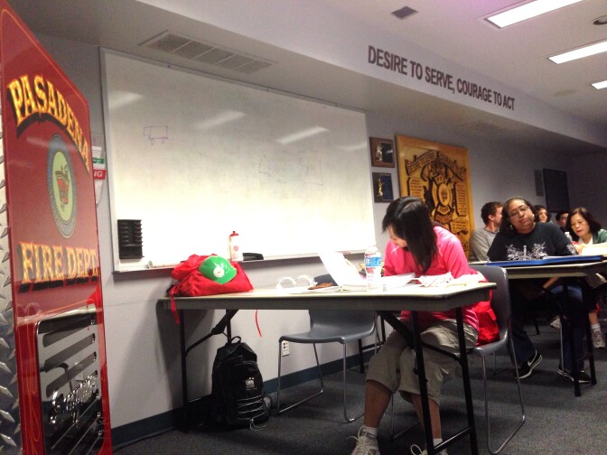 Pasadena resident Tao Kwan flips through her training book at the Pasadena Fire Department's emergency response training. Kwan was one of 24 people who attended Saturday's session.