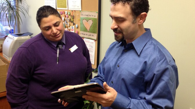 Priscilla Castillo, director of the Planned Parenthood clinic in Concord, and Jeff Novick, IT manager, look over a tablet. 