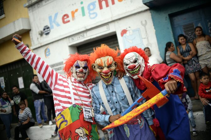 Revelers dressed as clowns take part in the traditional "Convite de fieros" festival, as part of All Saints Day celebrations in Villa Nueva, Guatemala on November 1, 2016.