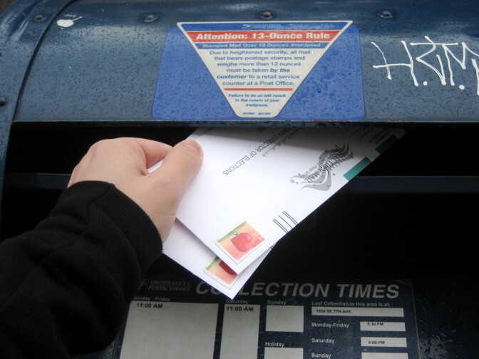 A mail-in ballot is placed into a mailbox. 