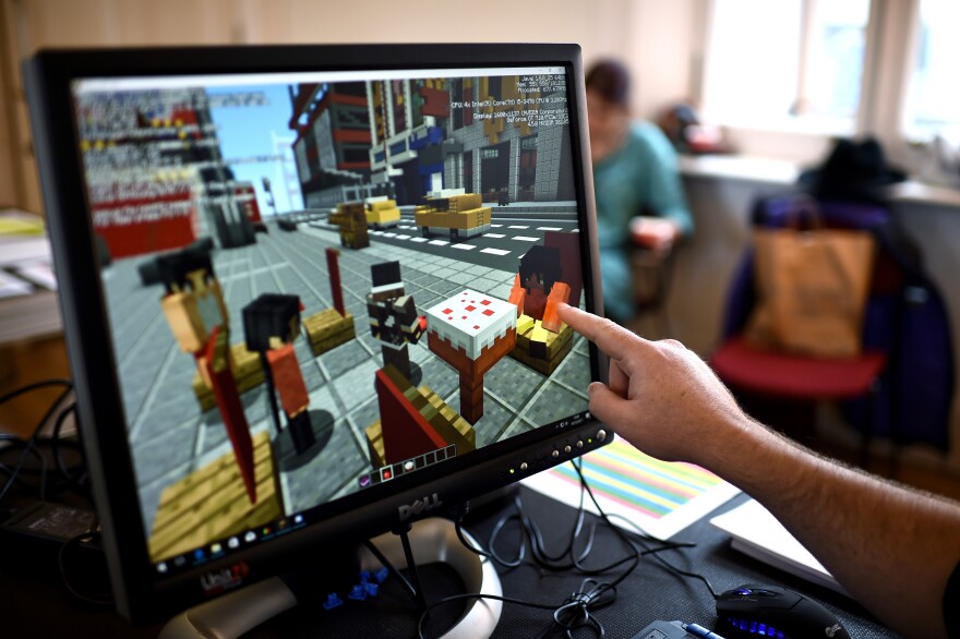 A Minecraft digital artist points at the digital version of the character Sal during a Playcraft live rehearsal at The Playhouse Theatre and Arts Centre on October 10, 2017 in Londonderry, Northern Ireland.