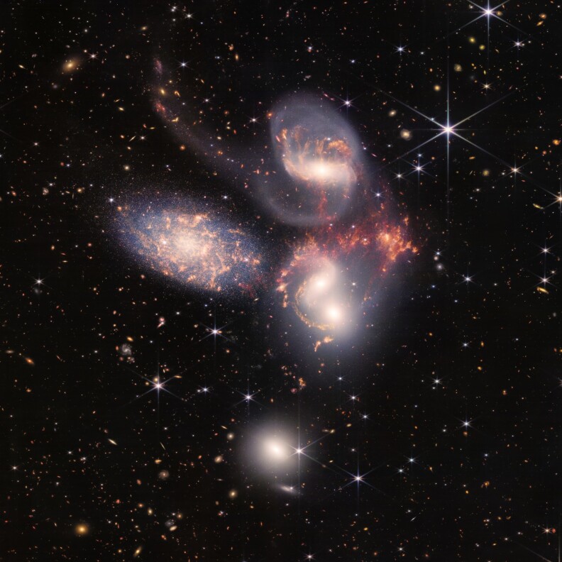 4 glowing shapes of various sizes appear with a field of stars behind.