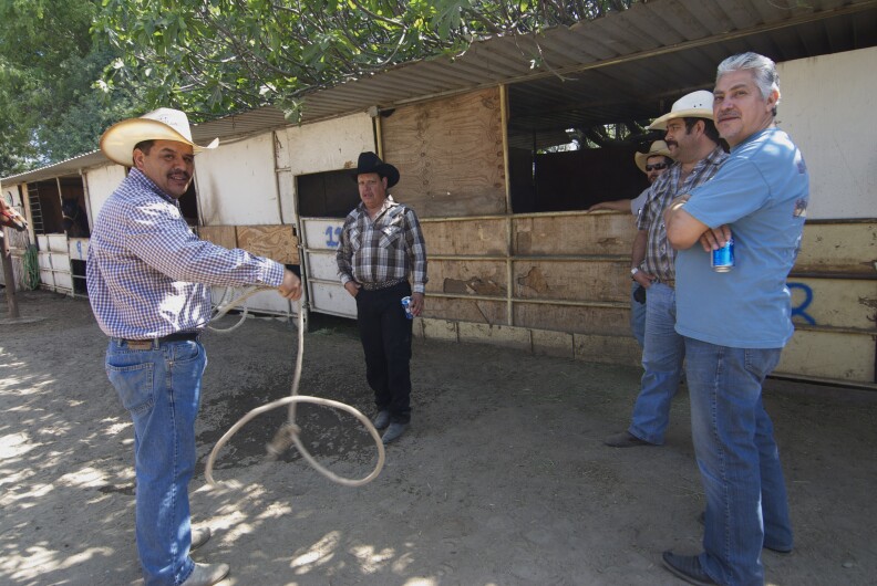 Cesar Ruvalcaba (L) twirls a lasso.