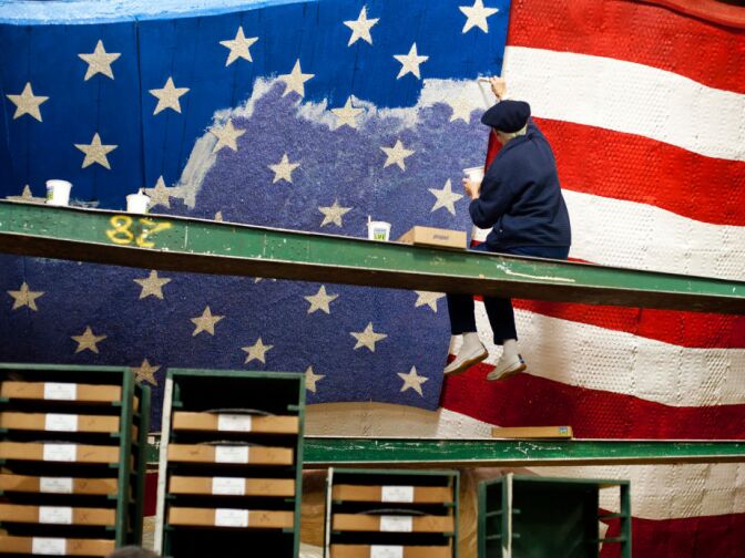 Shari Kennedy of Kiwanis International adds color to an American flag on a float in the Rosemont Pavilion on Thursday, days before the Rose Parade on New Year's Day. The float uses wheat, corn kernels, green tea leaves, parsley, and crushed split peas, among other materials, for its color.