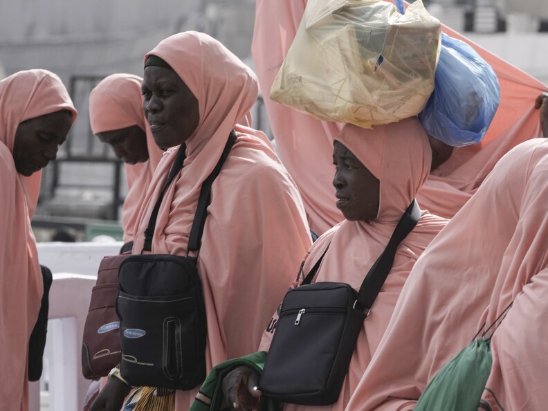 Nigerian pilgrims carry bags outside the Grand Mosque during the annual Hajj pilgrimage in Mecca, Saudi Arabia, Saturday, June 24, 2023. Straw hats, cross-body bags, and collapsible chairs are some essentials pilgrims have on them as they perform the Hajj.