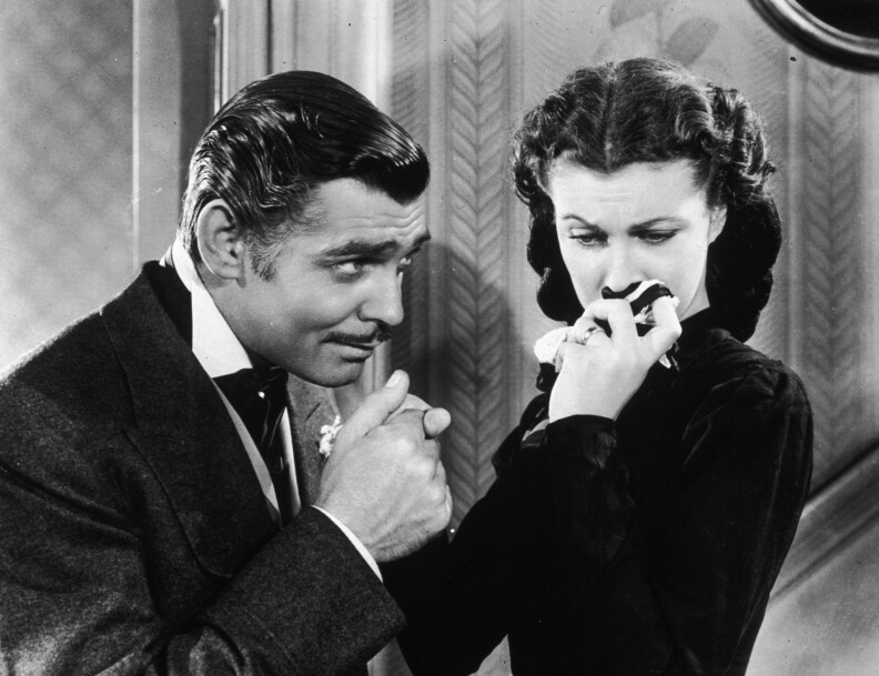 American actor Clark Gable (1901 - 1960) in his role as Rhett Butler kissing the hand of a tearful Scarlett O'Hara, played by Vivien Leigh in 'Gone With The Wind'.