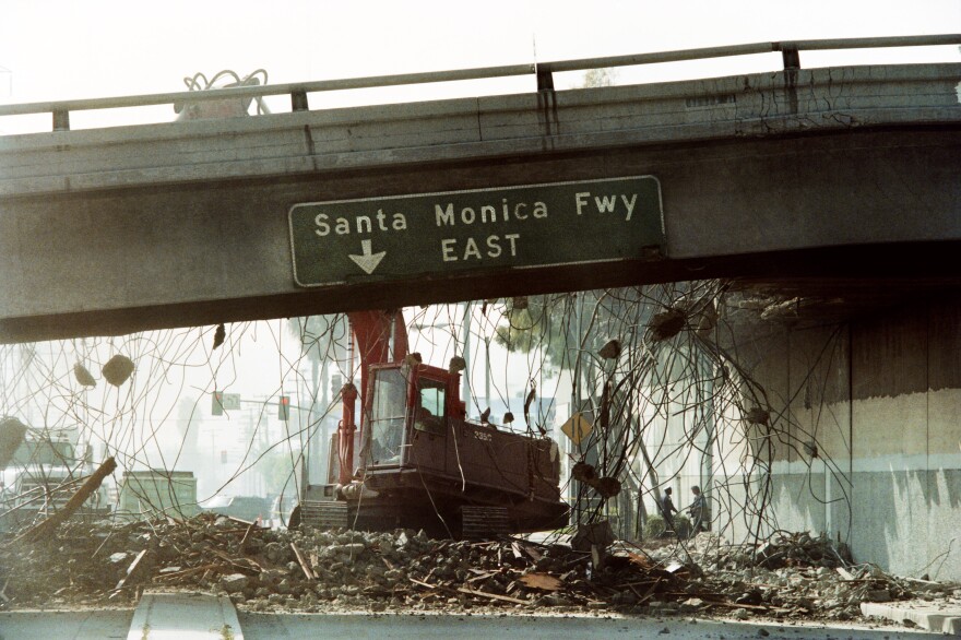 (Archive) A picture taken on January 19, 1994 in Los Angeles, California, shows a bulldozer tearing down a section of the Santa Monica Freeway that collapsed during the Northridge earthquake. Commuters were urged to leave for work two hours earlier due to the 300 foot section of the road that is closed. AFP PHOTO TIMOTHY CLARY (Photo credit should read TIMOTHY A. CLARY/AFP/Getty Images)