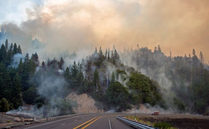 TOPSHOT - A fire truck drives along Highway 299 as they Carr fire continues to burn near Whiskeytown, California on July 28, 2018. - The US federal government approved aid on July 28 for California as thousands of firefighters battled to contain a series of deadly raging wildfires that have killed six people, including two young children and their great grandmother, and destroyed hundreds of buildings. (Photo by JOSH EDELSON / AFP)        (Photo credit should read JOSH EDELSON/AFP/Getty Images)